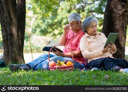Happy old elderly couple spouses relaxing and sitting on a blanket in the park and sharing few precious memories. Senior couple having great time together on a picnic. concept of mature relationships