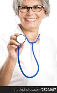 Happy old female doctor holding a stethoscope, isolated on white
