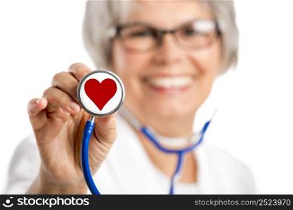 Happy old female doctor holding a stethoscope witha hearth on it, isolated on white