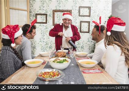 happy old man opening wine bottle festive table
