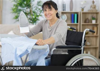 happy old woman in wheelchair irons clothes