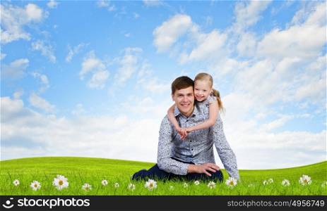 Happy parenting. Happy family of father and daughter sitting on grass