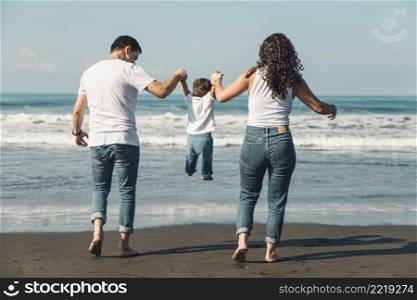 happy parents throwing their baby sunny beach