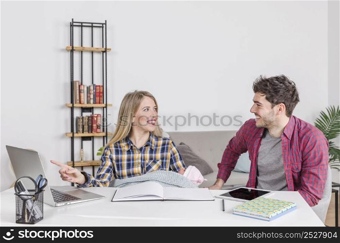 happy parents with baby pointing laptop screen
