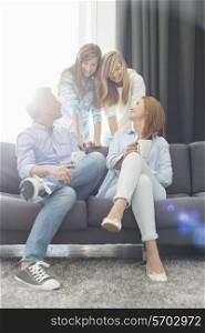 Happy parents with daughters spending quality time in living room