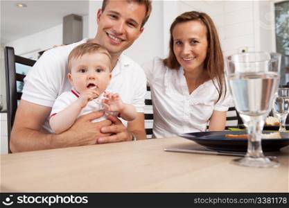 Happy parents with young boy child looking at the camera