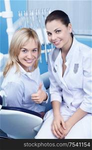 Happy patient in a dental chair with doctor