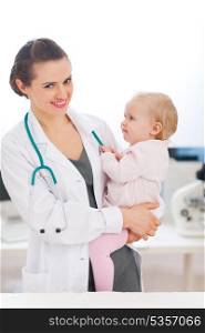 Happy pediatrician doctor with baby on examination