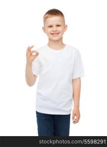 happy people and gesture concept - smiling little boy in blank white t-shirt showing ok gesture
