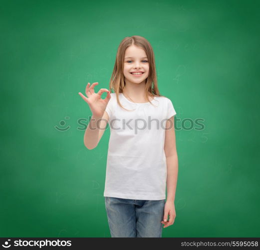 happy people and gesture concept - smiling little girl in blank white t-shirt showing ok gesture