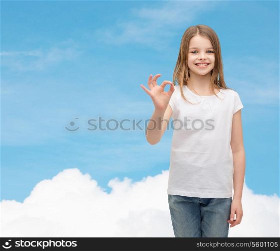happy people and gesture concept - smiling little girl in blank white t-shirt showing ok gesture