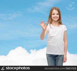 happy people and gesture concept - smiling little girl in blank white t-shirt showing ok gesture