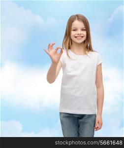 happy people and gesture concept - smiling little girl in blank white t-shirt showing ok gesture