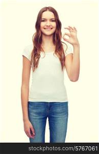 happy people concept - smiling woman in blank white t-shirt showing ok gesture