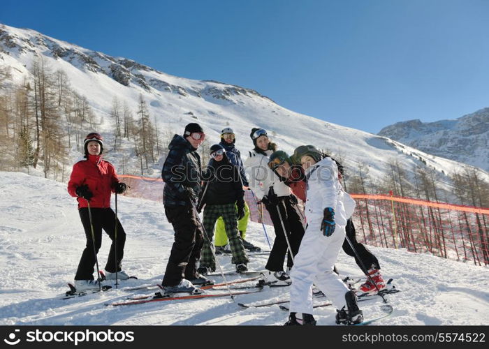 happy people group have fun on ski snow at winter season on mountain with blue sky and fresh air