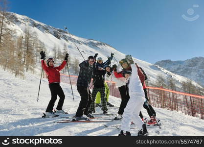 happy people group have fun on ski snow at winter season on mountain with blue sky and fresh air