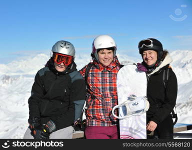 happy people group have fun on snow at winter season on mountain with blue sky and fresh air