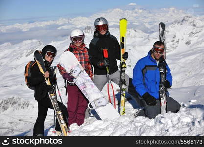 happy people group have fun on snow at winter season on mountain with blue sky and fresh air