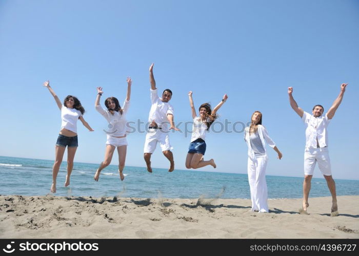 happy people group have fun run and jump on beach beautiful sand beach