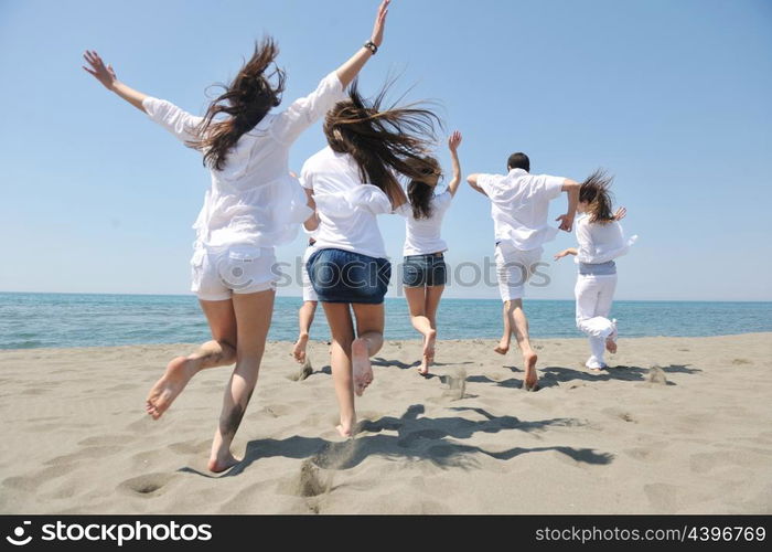 happy people group have fun run and jump on beach beautiful sand beach