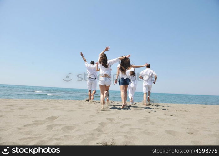 happy people group have fun run and jump on beach beautiful sand beach