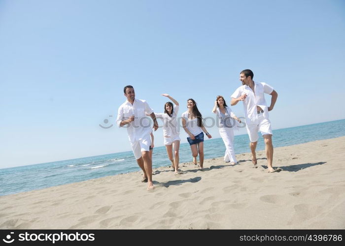 happy people group have fun run and jump on beach beautiful sand beach