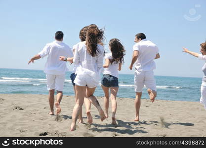 happy people group have fun run and jump on beach beautiful sand beach