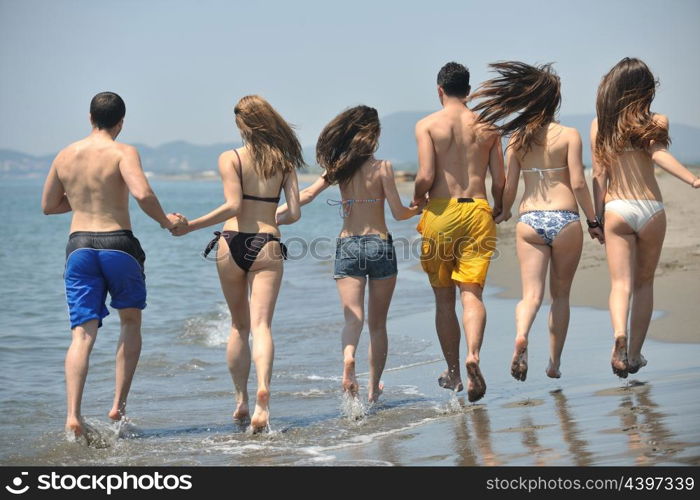 happy people group have fun run and jump on beach beautiful sand beach