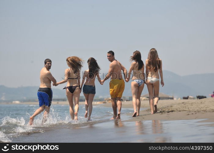 happy people group have fun run and jump on beach beautiful sand beach