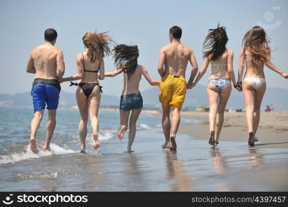 happy people group have fun run and jump on beach beautiful sand beach