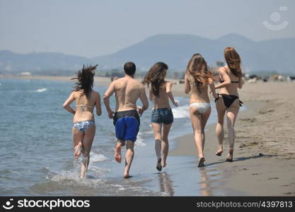 happy people group have fun run and jump on beach beautiful sand beach