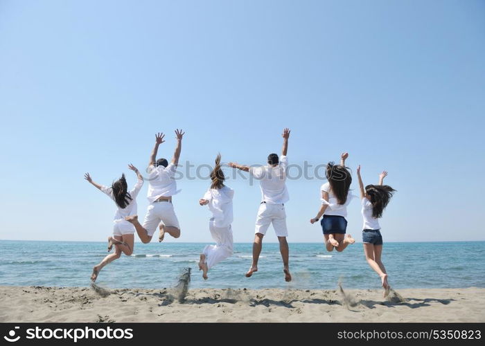 happy people group have fun run and jump on beach beautiful sand beach