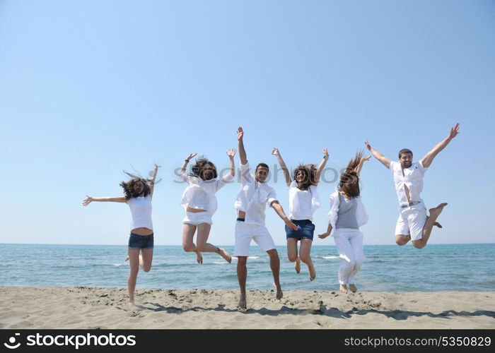 happy people group have fun run and jump on beach beautiful sand beach