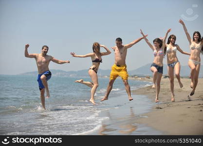 happy people group have fun run and jump on beach beautiful sand beach