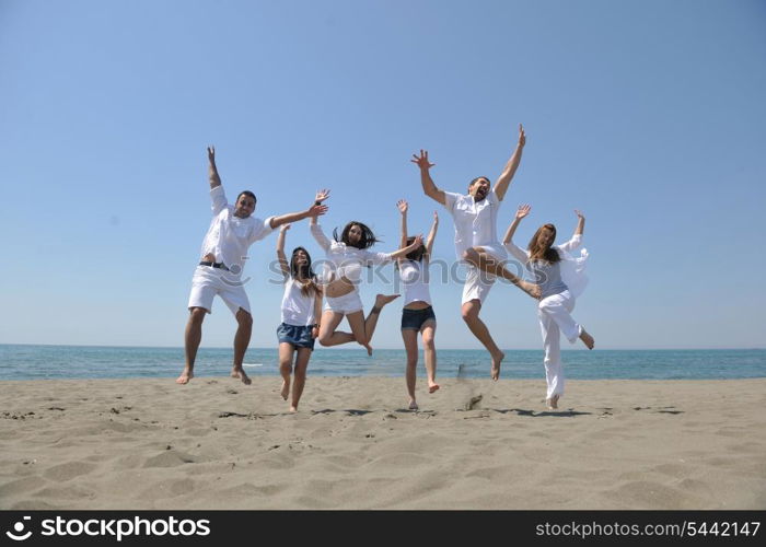 happy people group have fun run and jump on beach beautiful sand beach