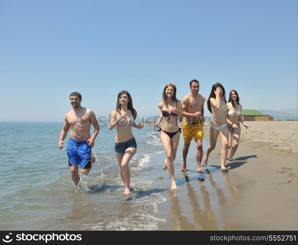 happy people group have fun run and jump on beach beautiful sand beach