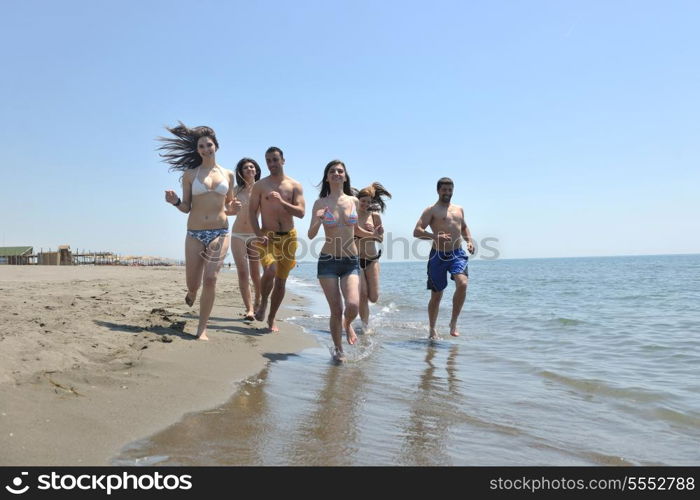 happy people group have fun run and jump on beach beautiful sand beach