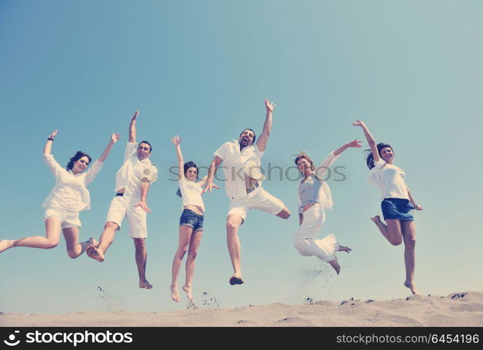 happy people group have fun run and jump on beach beautiful sand beach