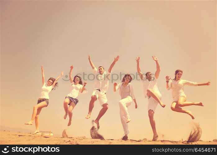 happy people group have fun run and jump on beach beautiful sand beach