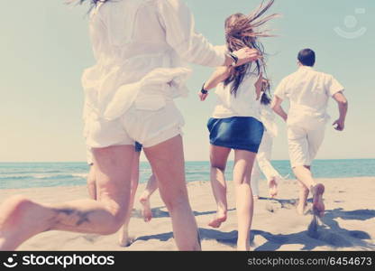 happy people group have fun run and jump on beach beautiful sand beach