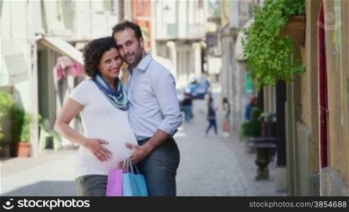 Happy people, husband, wife, man with pregnant woman shopping, having fun in city street. Portrait looking, smiling at camera. 4of7