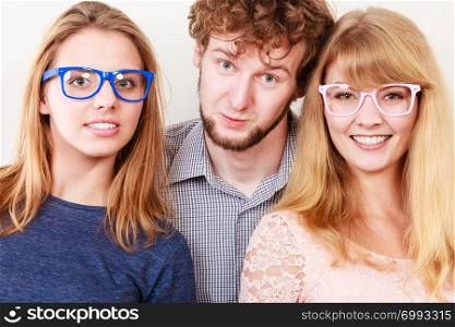 Happy playful young women in glasses. Smiling hipster friends girls and man having fun.