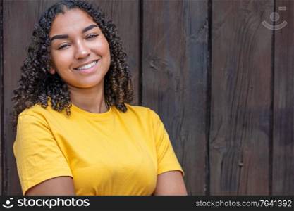 Happy portrait of a black mixed race biracial African American female young woman girl teenager teen outside smiling with perfect teeth