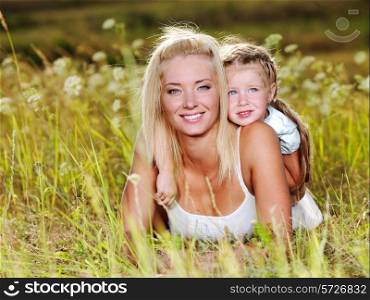 Happy portrait of the mother and little daughter outdoors