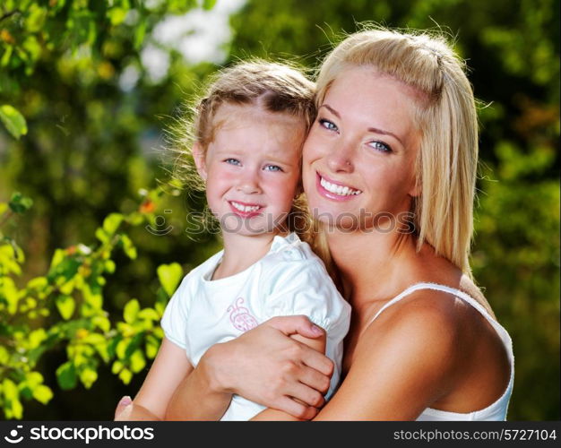 Happy portrait of the mother and little daughter outdoors