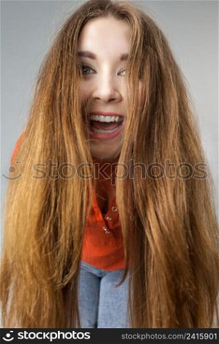 Happy positive woman with long brown hair presenting her healthy hairdo. Haircare concept.. Happy positive woman with long brown hair