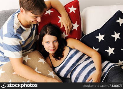 Happy pregnant couple on a sofa