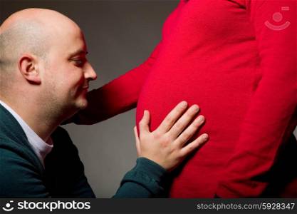 happy pregnant couple on dark background