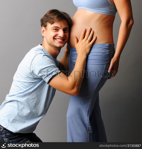 Happy pregnant couple over grey background