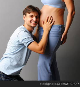 Happy pregnant couple over grey background